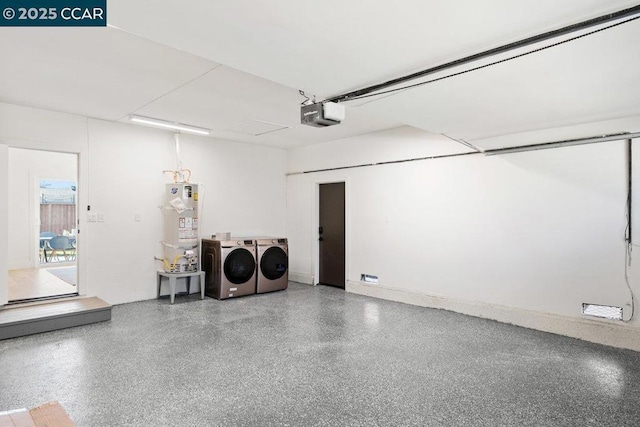 garage with strapped water heater, a garage door opener, and washer and clothes dryer