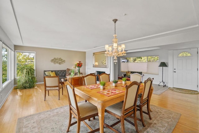 dining space with a chandelier and light hardwood / wood-style flooring