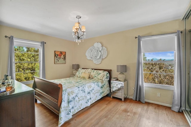 bedroom featuring a notable chandelier and light hardwood / wood-style flooring