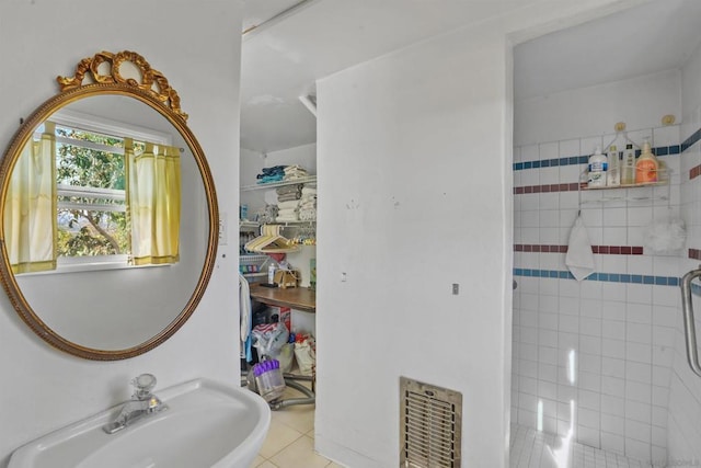 bathroom with tile patterned flooring, sink, and a shower