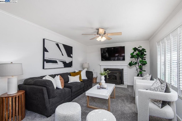 living room with a brick fireplace, ornamental molding, ceiling fan, and carpet flooring