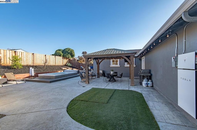 view of patio / terrace featuring a gazebo, area for grilling, and a jacuzzi