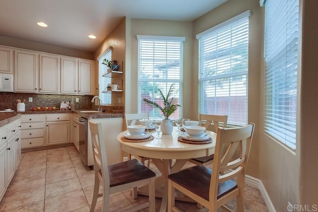 kitchen featuring sink, light tile patterned floors, dishwasher, white cabinetry, and tasteful backsplash