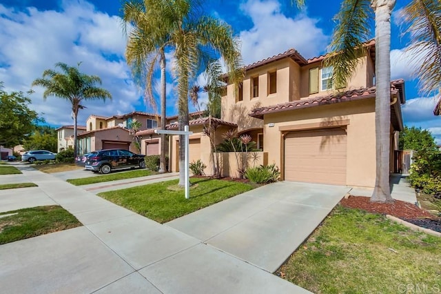 mediterranean / spanish-style home with a garage and a front lawn