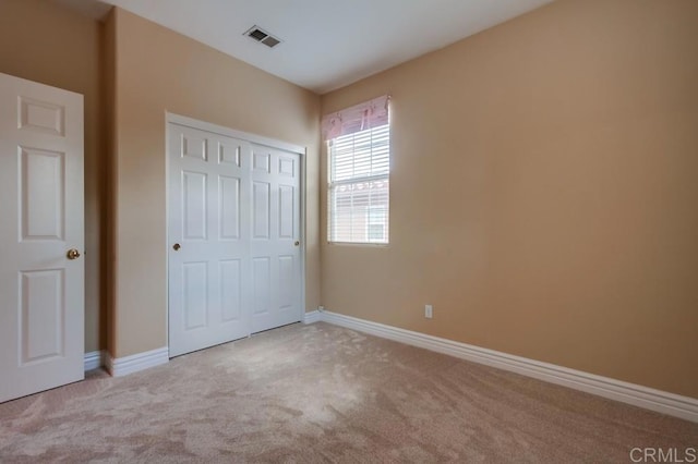 unfurnished bedroom featuring carpet flooring and a closet