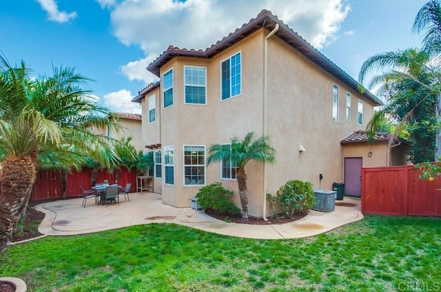 back of house with a yard and a patio