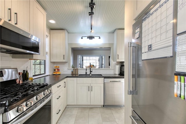 kitchen featuring light tile patterned flooring, a healthy amount of sunlight, stainless steel appliances, and sink