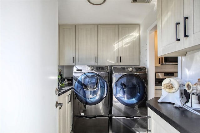 washroom with cabinets and separate washer and dryer