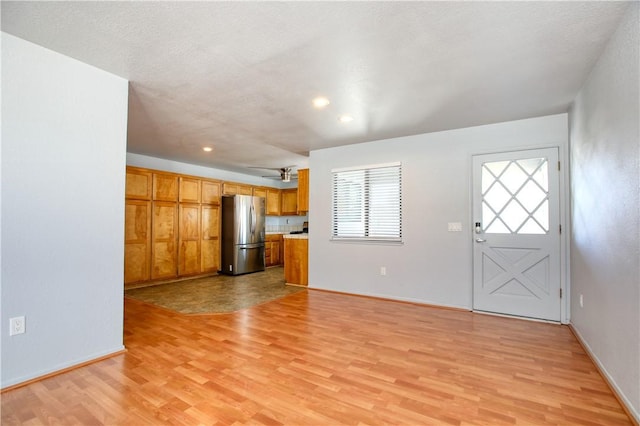 unfurnished living room featuring light hardwood / wood-style flooring and ceiling fan