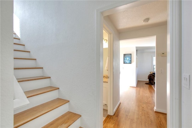 stairway featuring hardwood / wood-style floors and a textured ceiling