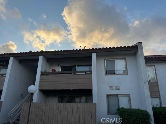 property exterior at dusk featuring a balcony