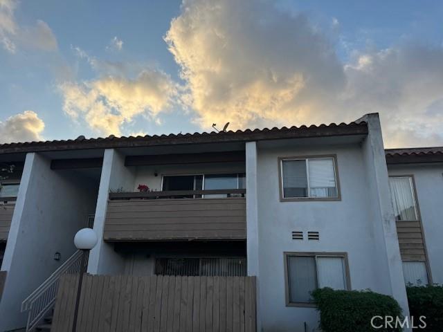 2501 W Sunflower Unit F12, Santa Ana, CA 92704 - back of house at dusk with stucco siding and a balcony
