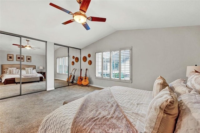 bedroom with two closets, vaulted ceiling, ceiling fan, and carpet