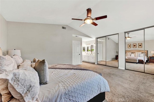 carpeted bedroom featuring ceiling fan, lofted ceiling, and two closets