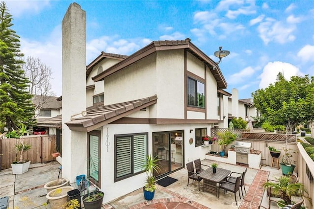 rear view of house featuring area for grilling and a patio area