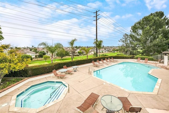 view of swimming pool featuring a community hot tub and a patio