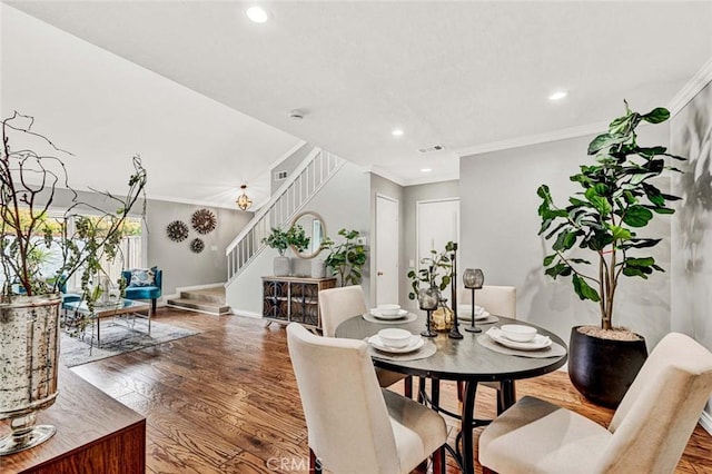 dining space with crown molding and hardwood / wood-style flooring