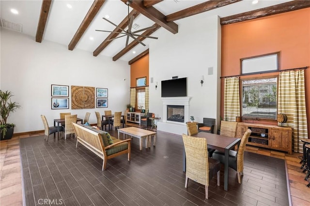 living room with beam ceiling, ceiling fan, and high vaulted ceiling