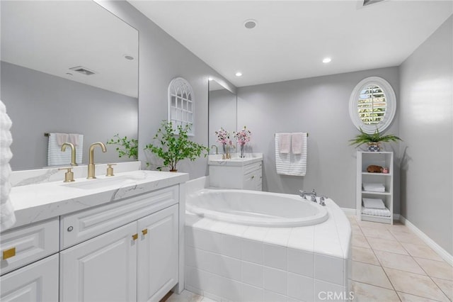 bathroom featuring tile patterned floors, vanity, and tiled bath