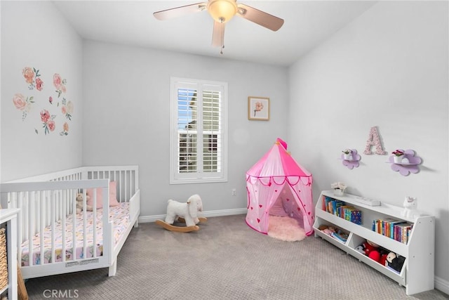 bedroom with carpet floors, a crib, and ceiling fan