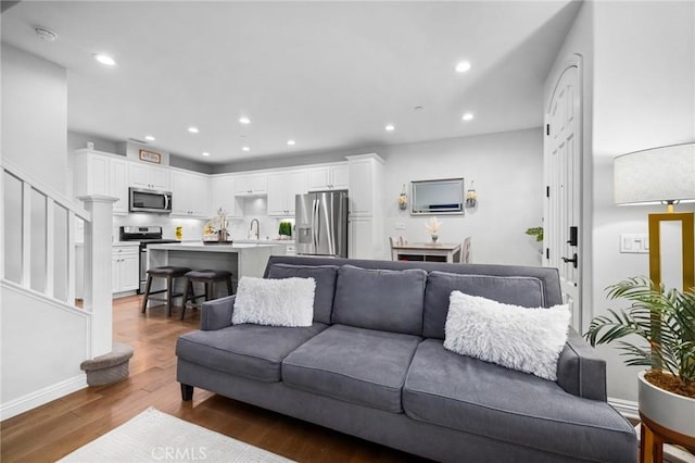 living room with wood-type flooring and sink