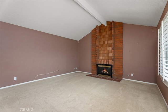 unfurnished living room featuring lofted ceiling with beams, a brick fireplace, and carpet