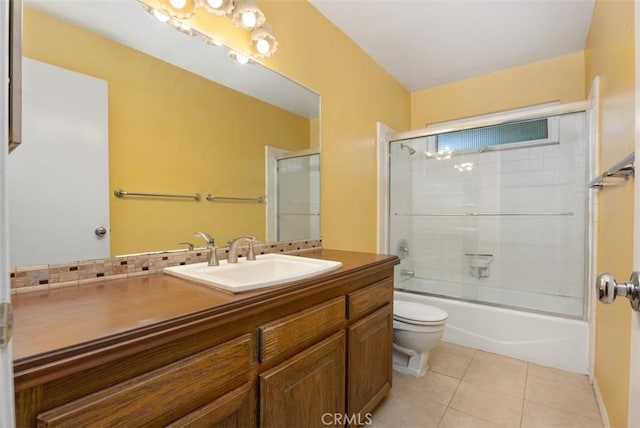 full bathroom with tile patterned flooring, vanity, shower / bath combination with glass door, and toilet