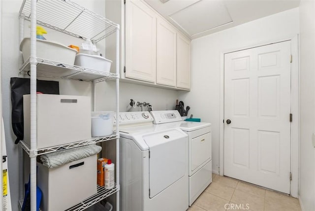 laundry area with cabinets, washer and clothes dryer, and light tile patterned floors