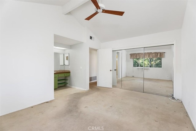 unfurnished bedroom with ceiling fan, high vaulted ceiling, carpet, a closet, and beamed ceiling