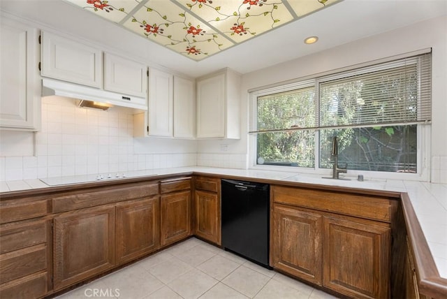 kitchen with light tile patterned flooring, sink, tile counters, dishwasher, and electric stovetop