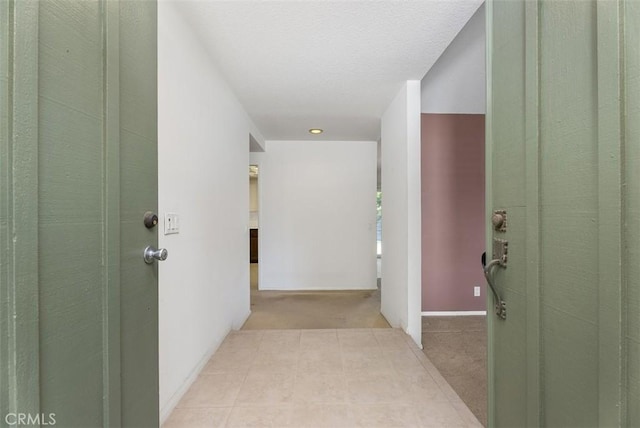 hallway featuring light colored carpet