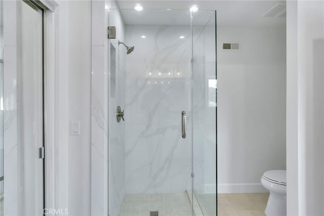 bathroom with a shower with door and toilet