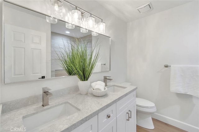 bathroom featuring vanity, hardwood / wood-style floors, and toilet