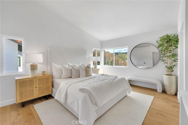 bedroom featuring lofted ceiling and hardwood / wood-style floors