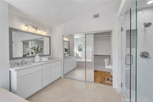 bathroom featuring vanity, a shower with door, and vaulted ceiling