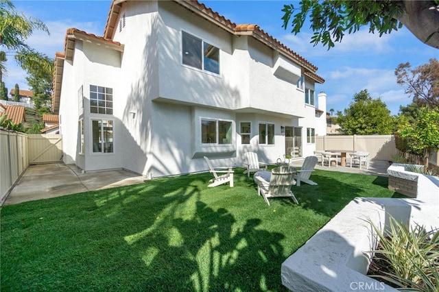 rear view of house featuring a patio area and a lawn