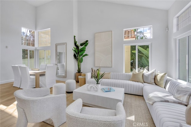 living room with a towering ceiling and light wood-type flooring