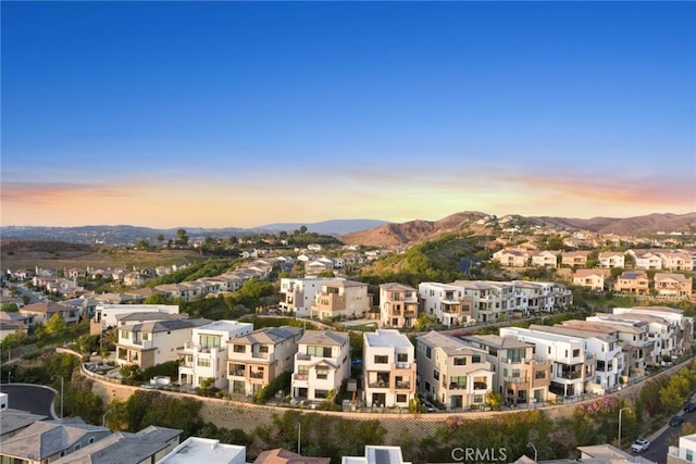 aerial view at dusk featuring a mountain view