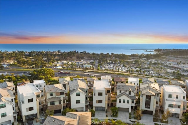 aerial view at dusk featuring a water view