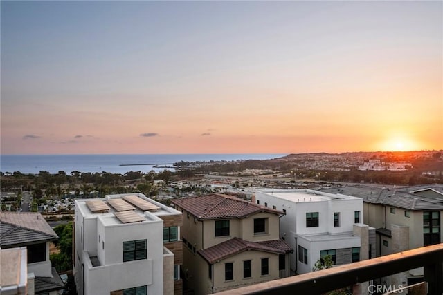 aerial view at dusk featuring a water view