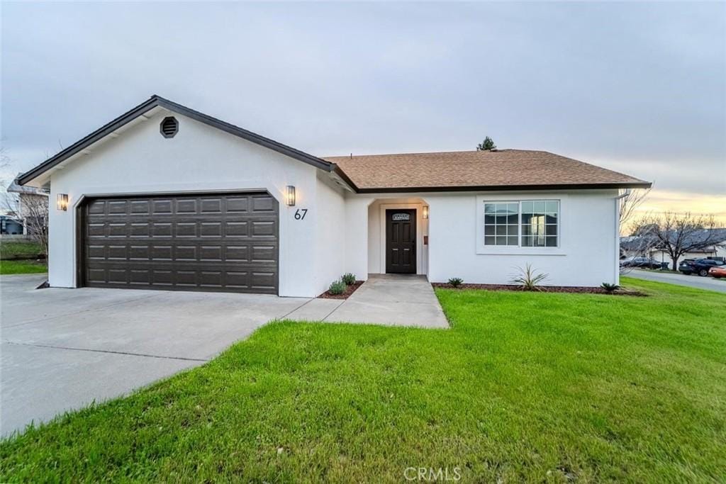 ranch-style house featuring a garage and a front lawn