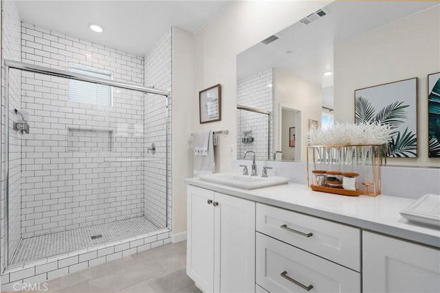 bathroom featuring vanity, tile patterned flooring, and a shower with shower door