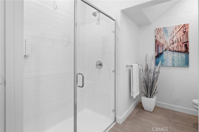 bathroom with a shower with door and toilet