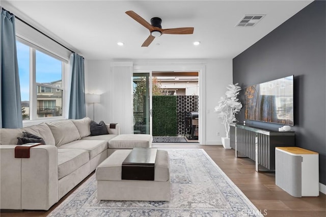 living room with wood-type flooring and ceiling fan