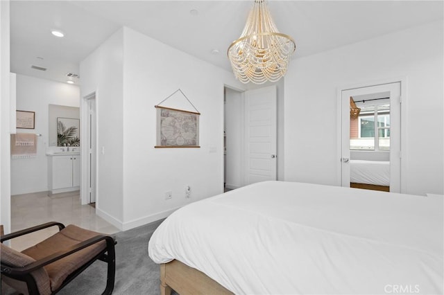 bedroom with connected bathroom and a notable chandelier