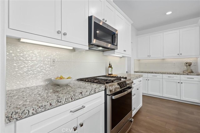 kitchen with white cabinetry, light stone countertops, and appliances with stainless steel finishes