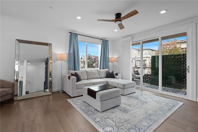 living room with wood-type flooring and ceiling fan