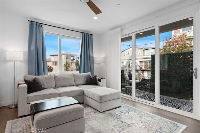 living room with wood-type flooring, plenty of natural light, and ceiling fan