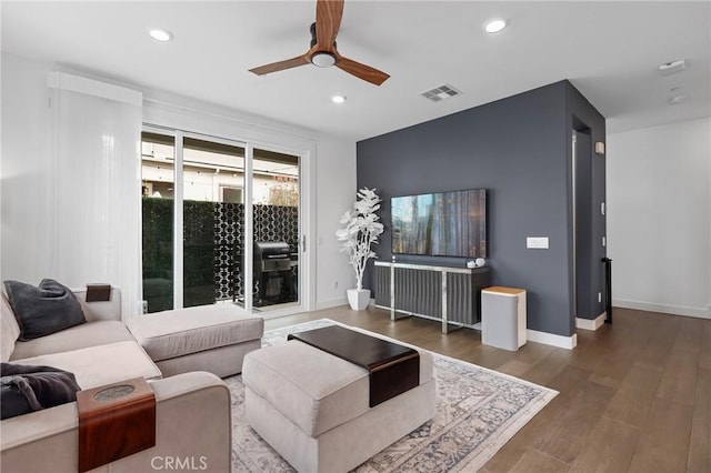 living room featuring dark hardwood / wood-style flooring and ceiling fan