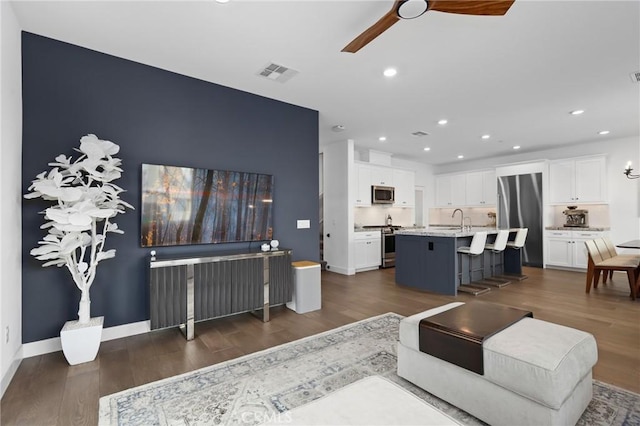 living room featuring sink, dark hardwood / wood-style floors, and ceiling fan